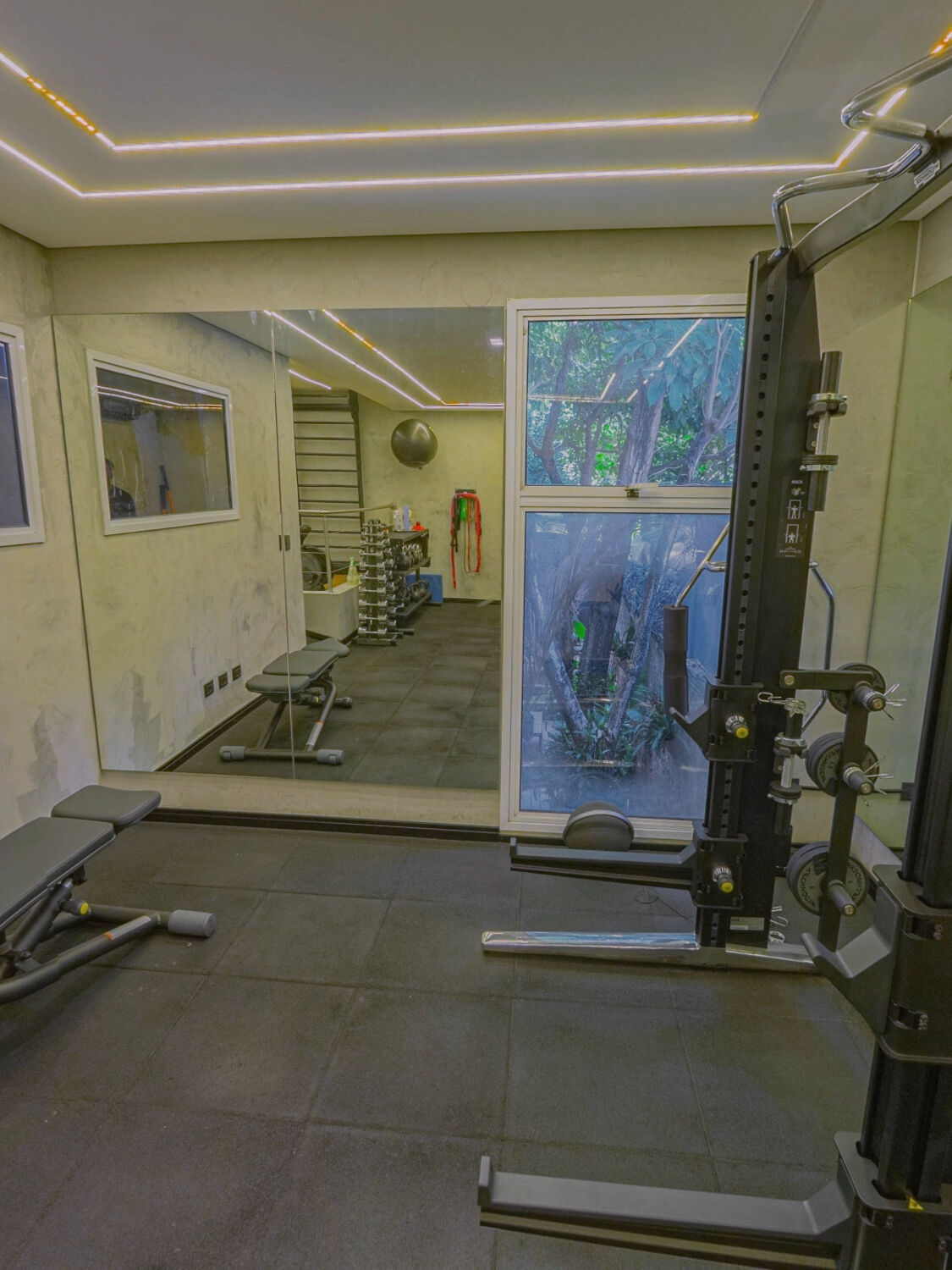 Sala do studio no Anacã, com o rack e a janela para o jardim